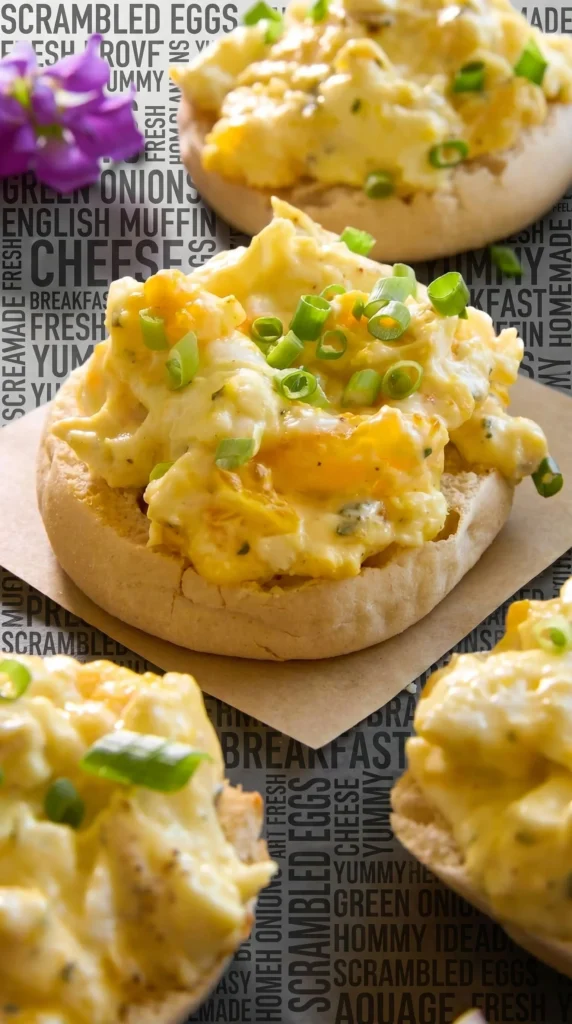 Delicious cheesy scrambled eggs served on a plate with herbs
